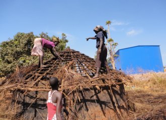 Women of Awoo Village in Karuma trying to remove some of the building materials fromtheir huts as they are being evicted- Photographer unknown_kleiner